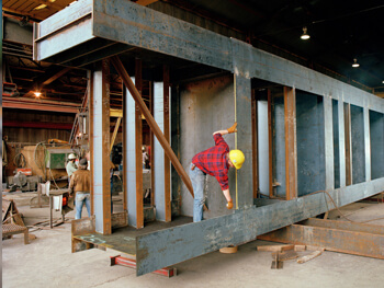 Workers completing a custom steel fabrication piece at our shop for a project in Colombia.